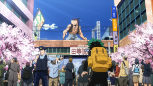 Izuku Midoriya (Deku) watching a giant villain attack in a city street lined with cherry blossoms in My Hero Academia.