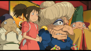 Chihiro Ogino standing nervously before the imposing witch Yubaba, the bathhouse proprietor in Spirited Away.